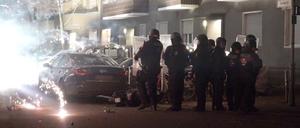 Polizisten stehen in der Silvesternacht 2022 hinter explodierendem Feuerwerk. (Archivbild)