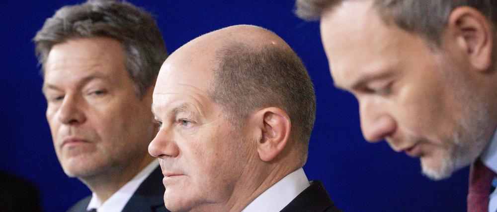 Bundeswirtschafts- und Klimaminister Robert Habeck (Grüne, l.) gemeinsam mit Bundeskanzler Olaf Scholz (SPD, M.) und Bundesfinanzminister Christian Lindner (FDP, r.).