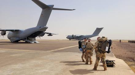 Bundeswehrsoldaten stehen vor Transportmaschinen der Bundeswehr, um mit den Fliegern Mali zu verlassen.