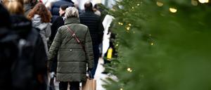 Menschen gehen mit Einkaufstüten am verkaufsoffenen Sonntag durch Berlin-Mitte. 