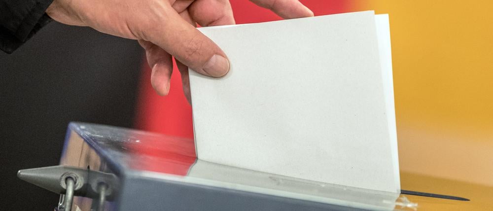 Ein Wähler wirft einen Stimmzettel in die Wahlurne.