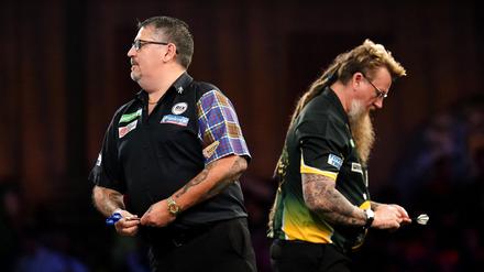 Gary Anderson in Aktion. Simon Whitlock geht im Hintergrund vorbei.