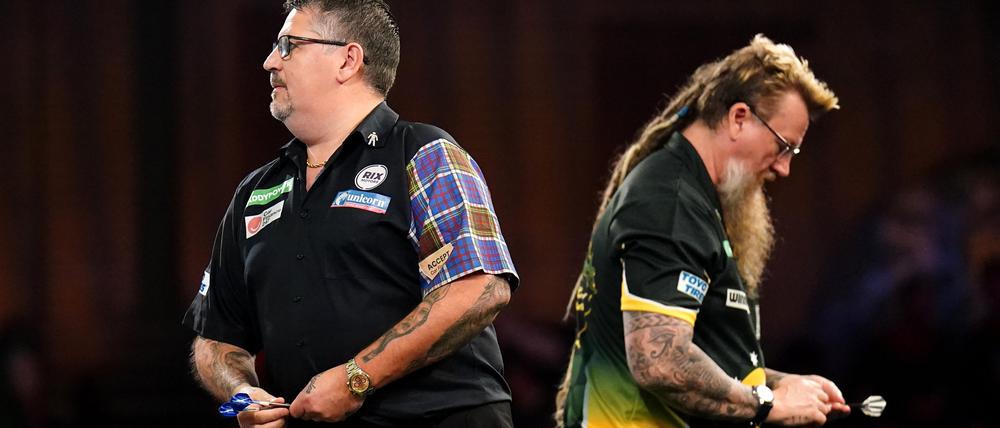 Gary Anderson in Aktion. Simon Whitlock geht im Hintergrund vorbei.