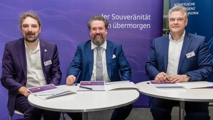 15.12.2023, Brandenburg, Cottbus: Daniel Mayer (r-l), Kaufmännischen Direktor der Agentur für Innovation in der Cybersicherheit GmbH (Cyberagentur), Thorsten Zander, Geschäftsführer und Projektleiter von Zander Labs sowie Lichtenberg-Professor für Neuroadaptive Mensch-Technik-Interaktion an der Brandenburgischen Technischen Universität Cottbus-Senftenberg (BTU), und Christian Hummert, Forschungsdirektor Cyberagentur, sitzen bei der Vertragsunterzeichnung zwischen der Agentur für Innovation in der Cybersicherheit GmbH (Cyberagentur) und dem Cottbuser Startup Zander Laboratories GmbH. Die Agentur für Innovation in der Cybersicherheit möchte einen Vertrag über 30 Millionen Euro mit dem Cottbuser Startup «Zander Laboratories» unterzeichnen. Das Unternehmen soll in vier Jahren neurotechnologische Prototypen, zur Interaktion zwischen Mensch und Maschine, entwickeln. Foto: Frank Hammerschmidt/dpa +++ dpa-Bildfunk +++