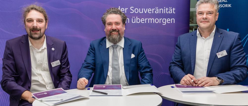 15.12.2023, Brandenburg, Cottbus: Daniel Mayer (r-l), Kaufmännischen Direktor der Agentur für Innovation in der Cybersicherheit GmbH (Cyberagentur), Thorsten Zander, Geschäftsführer und Projektleiter von Zander Labs sowie Lichtenberg-Professor für Neuroadaptive Mensch-Technik-Interaktion an der Brandenburgischen Technischen Universität Cottbus-Senftenberg (BTU), und Christian Hummert, Forschungsdirektor Cyberagentur, sitzen bei der Vertragsunterzeichnung zwischen der Agentur für Innovation in der Cybersicherheit GmbH (Cyberagentur) und dem Cottbuser Startup Zander Laboratories GmbH. Die Agentur für Innovation in der Cybersicherheit möchte einen Vertrag über 30 Millionen Euro mit dem Cottbuser Startup «Zander Laboratories» unterzeichnen. Das Unternehmen soll in vier Jahren neurotechnologische Prototypen, zur Interaktion zwischen Mensch und Maschine, entwickeln. Foto: Frank Hammerschmidt/dpa +++ dpa-Bildfunk +++
