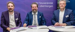 15.12.2023, Brandenburg, Cottbus: Daniel Mayer (r-l), Kaufmännischen Direktor der Agentur für Innovation in der Cybersicherheit GmbH (Cyberagentur), Thorsten Zander, Geschäftsführer und Projektleiter von Zander Labs sowie Lichtenberg-Professor für Neuroadaptive Mensch-Technik-Interaktion an der Brandenburgischen Technischen Universität Cottbus-Senftenberg (BTU), und Christian Hummert, Forschungsdirektor Cyberagentur, sitzen bei der Vertragsunterzeichnung zwischen der Agentur für Innovation in der Cybersicherheit GmbH (Cyberagentur) und dem Cottbuser Startup Zander Laboratories GmbH. Die Agentur für Innovation in der Cybersicherheit möchte einen Vertrag über 30 Millionen Euro mit dem Cottbuser Startup «Zander Laboratories» unterzeichnen. Das Unternehmen soll in vier Jahren neurotechnologische Prototypen, zur Interaktion zwischen Mensch und Maschine, entwickeln. Foto: Frank Hammerschmidt/dpa +++ dpa-Bildfunk +++