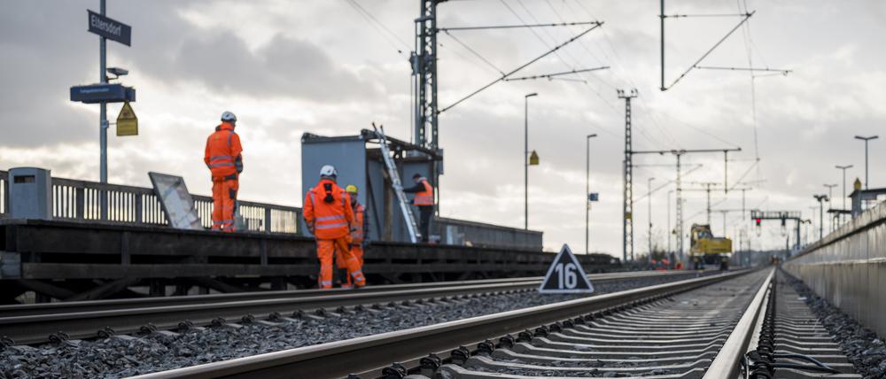 Arbeiter stehen am Bahnhof im Gleisbett und demontieren den Behelfsbahnsteig aus Holz an der Bahnbaustelle für die ICE-Strecke zwischen Nürnberg und Bamberg.