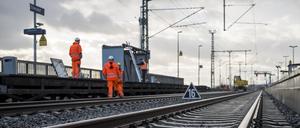 Arbeiter stehen am Bahnhof im Gleisbett und demontieren den Behelfsbahnsteig aus Holz an der Bahnbaustelle für die ICE-Strecke zwischen Nürnberg und Bamberg. 