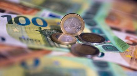 Geldscheine mit dem Wert von 100 und 50 Euro und Münzen liegen auf einem Tisch (Symbolfoto).