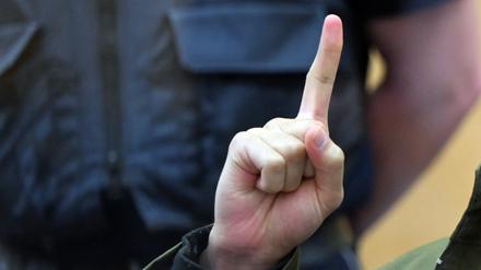 Der Angeklagte Maan D.  wartet im Prozess um die Messerattacken von Duisburg auf den Beginn der Verhandlung und zeigt den Gruß der Kämpfer des IS, Tauhid.