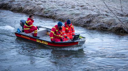 19.12.2023, Baden-Württemberg, Bingen-Hitzkofen: Einsatzkräfte der DLRG suchen per Sonarabsuche das Gewässer der Lauchert nach einem zweijährigen Kind ab.