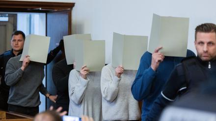 Die fünf angeklagten Polizeibeamtinnen und -beamten kommen in den Gerichtssaal des Landgerichts.