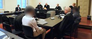 Die angeklagten syrischen Brüder (3.v.l und r) sitzen zu Beginn des Prozesses wegen mutmaßlicher Vorbereitung eines Sprengstoffanschlags neben ihren Anwälten im Sitzungssaal im Strafjustizgebäude. (Archivbild). 