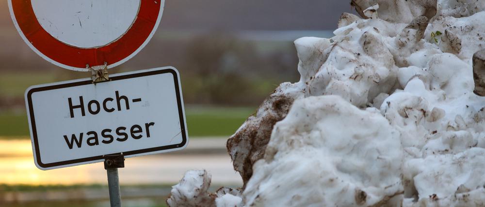 Neben einem Schneehaufen steht an der Donau ein Schild mit der Aufschrift „Hochwasser“. (Archivbild von 2023)