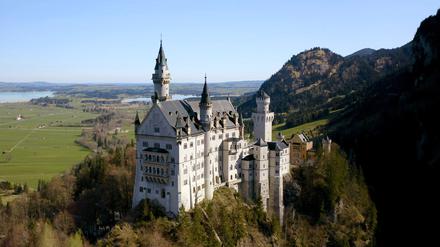 Hoch oben auf einem steilen Berggipfel thront Schloss Neuschwanstein.