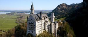 Hoch oben auf einem steilen Berggipfel thront Schloss Neuschwanstein.