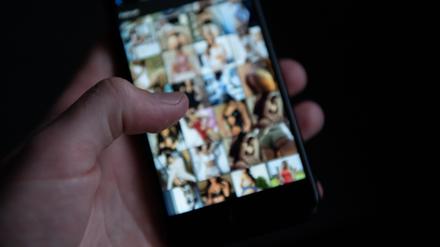Auf einem Smartphone sind pornografische Bilder zu sehen. 