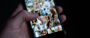 Auf einem Smartphone sind pornografische Bilder zu sehen. 