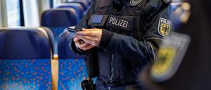 Bundespolizisten kontrollieren die Papiere eines Reisenden im Rahmen einer Einreiseverkehrskontrolle in einem Zug aus Prag in Richtung München.