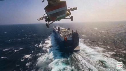 Ein Huthi-Hubschrauber fliegt am 19.11.2023 über das Frachtschiff „Galaxy Leader“.