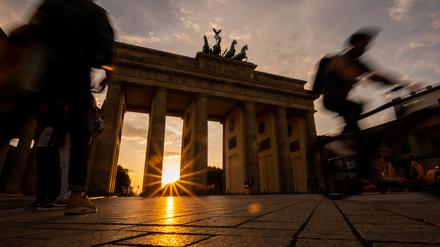 Die Sonne geht hinter dem Brandenburger Tor unter.