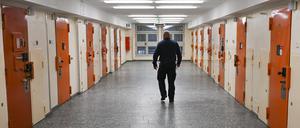 ARCHIV - 07.12.2023, Berlin: Ein Vollzugsbeamter geht in der Zugangsabteilung der Justizvollzugsanstalt Moabit an Zellentüren vorbei.      (zu dpa "Handys und Drogen in Gefängnissen") Foto: Jens Kalaene/dpa +++ dpa-Bildfunk +++