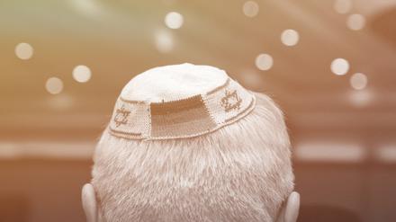 Ein Mann trägt eine Kippa mit eingearbeiteten israelischen und deutschen Fahnen. 