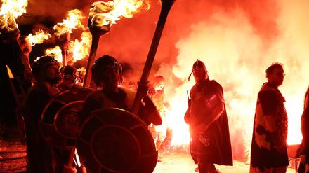 Großbritannien, Lerwick: Mitglieder des Jarl-Gefolges zünden ihre Fackeln während des Festes „Up Helly Aa“, einem Wikingerfest auf den Shetland-Inseln, an. 