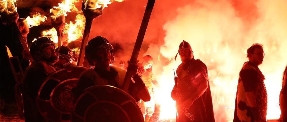 Großbritannien, Lerwick: Mitglieder des Jarl-Gefolges zünden ihre Fackeln während des Festes „Up Helly Aa“, einem Wikingerfest auf den Shetland-Inseln, an. 