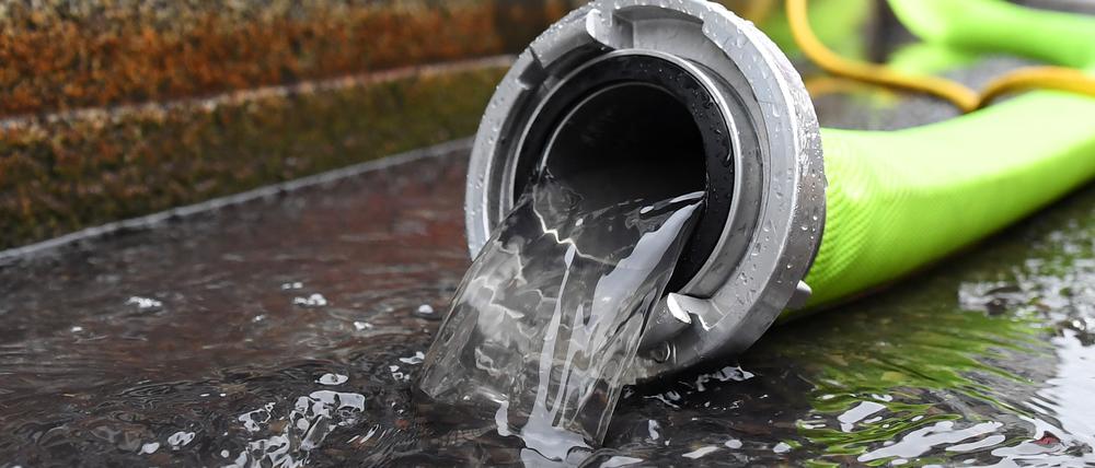 Feuerwehrleute pumpen in Berlin-Mitte Wasser einen Keller aus. Symbolbild