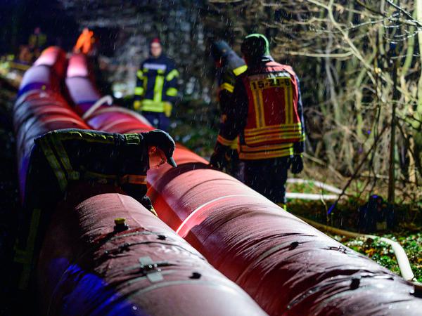 Ehrenamtliche Einsatzkräfte der Feuerwehr bauen in Wienhausen einen Mobildeich auf. 