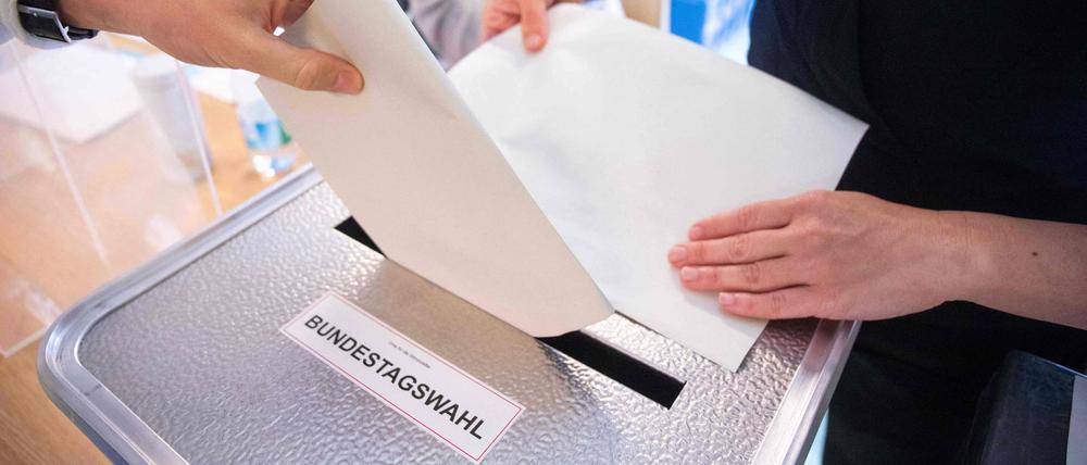 Bei der letzten Bundestagswahl 2021 wirft ein Wähler seinen Stimmzettel in die Wahlurne.