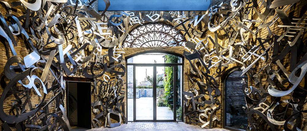 Blick vom Entree in den Garten, den Raum füllt eine Buchstabenarbeit von Jaume Plensa.