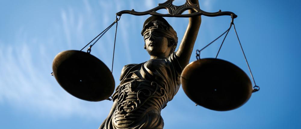Eine Statue der Justitia hält eine Waage in der Hand. 