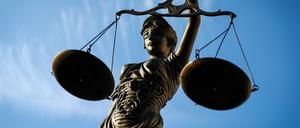 Eine Statue der Justitia hält eine Waage in der Hand. 