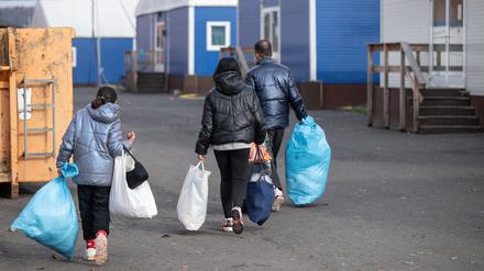 In Plastiksäcken tragen neu angekommene Flüchtlinge ihre persönlichen Habseligkeiten zu ihrer Unterkunft in der Erstaufnahmeeinrichtung (HEAE) in Gießen.