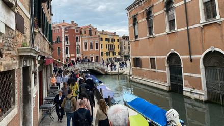 Touristen gehen in großen Gruppen durch das Stadtzentrum von Venedig.