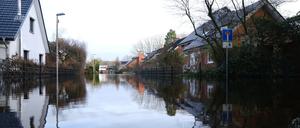 Eine Straße in einem Wohngebiet in Lilienthal steht unter Wasser. Hier ist die Wümme über die Ufer getreten. Die Anwohnerinnen und Anwohner des Ortes können ihre Häuser nur noch mit Booten erreichen. 