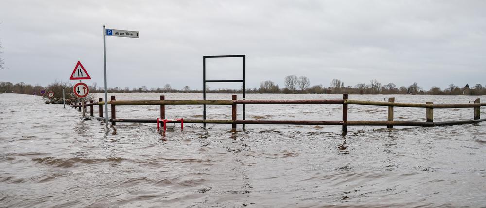 01.01.2024, Niedersachsen, Achim: Das Hochwasser der Weser steht auf den Wiesen in Achim-Baden. Zahlreiche Helfer sind im Landkreis Verden unterwegs, um Deiche zu sichern und Wohngebiete vor dem Hochwasser von Aller, Weser und Wümme zu schützen.