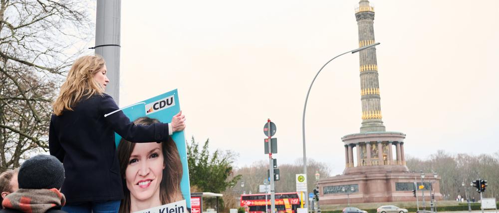 02.01.2024, Berlin: Ottilie Klein (CDU), Direktkandidatin für den Wahlkreis Berlin-Mitte und Generalsekretärin, hängt ein Plakat mit ihrem Konterfei vor der Siegessäule auf. In Berlin muss die Bundestagswahl in einigen Stimmbezirken wiederholt werden. Foto: Annette Riedl/dpa +++ dpa-Bildfunk +++