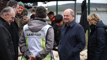Bundeskanzler Olaf Scholz bespricht die Flutlage mit dem Landrat von Mansfeld-Südharz, André Schröder (CDU), bei einem Besuch der zentralen Sandsackbefüllungsanlage in Berga.