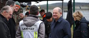 Bundeskanzler Olaf Scholz bespricht die Flutlage mit dem Landrat von Mansfeld-Südharz, André Schröder (CDU), bei einem Besuch der zentralen Sandsackbefüllungsanlage in Berga.