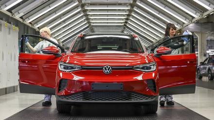 Mitarbeiterinnen prüfen einen ID.4 im Lichttunnel im Werk von Volkswagen in Zwickau. 
