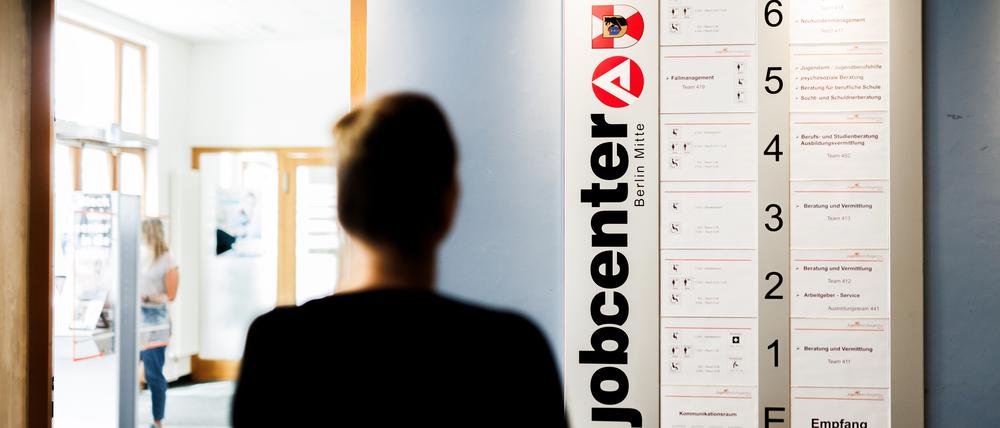 Alles klar? Eine Frau steht vor einer Informationstafel im Eingangsbereich der Jugendberufsagentur Berlin.