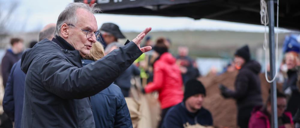 Rainer Haseloff (CDU), Ministerpräsident von Sachsen-Anhalt, reagiert auf einen Pöbler bei der zentralen Sandsackbefüllungsanlage.