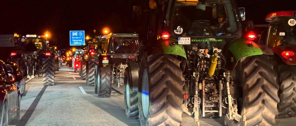 22.12.2023, Rheinland-Pfalz, Bendorf: Landwirte fahren mit ihren Traktoren in Kolonnen auf der Autobahn A48. Nach Polizeiangaben nehmen mehr als 400 Traktoren aus Rheinland-Pfalz in Koblenz an einem Protestzug teil und sperren zeitweise den Verkehr auf der Autobahnbrücke Bendorf der A48. Die Landwirte protestieren gegen die geplante Streichung von Steuervergünstigungen durch die Bundesregierung. Foto: Thomas Frey/dpa +++ dpa-Bildfunk +++