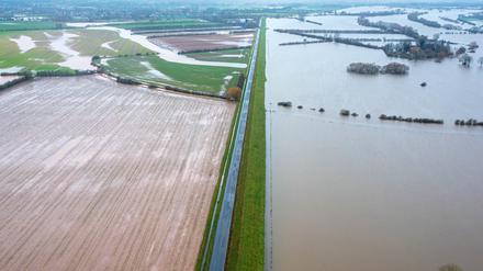 Wasser steht in Thedinghausen in Niedersachsen am für den Verkehr gesperrten Deich (Aufnahme mit Drohne). 