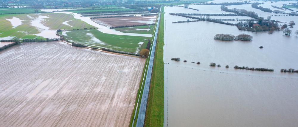 Wasser steht in Thedinghausen in Niedersachsen am für den Verkehr gesperrten Deich (Aufnahme mit Drohne). 