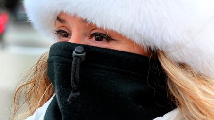 Dick eingepackt spaziert diese Touristin bei Temperaturen um Minus 12 Grad Celsius vor dem Brandenburger Tor durch das frostige Berlin. 