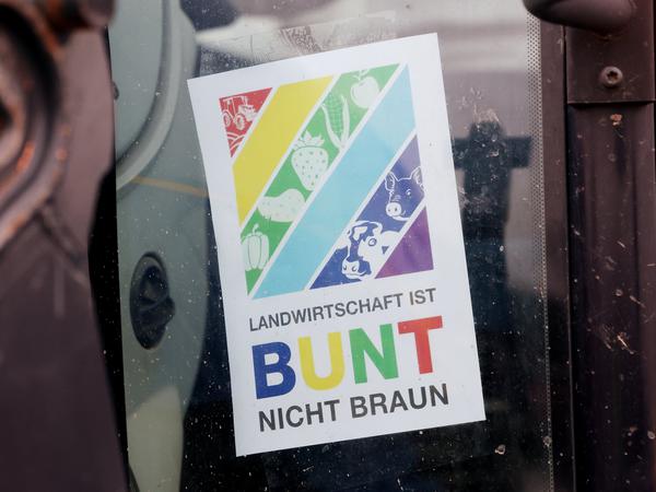 Ein Schild mit der Aufschrift „Landwirtschaft Ist Bunt Nicht Braun“ hängt in Düsseldorf am Rande einer Demonstration von Bauern an einem Fahrzeug.